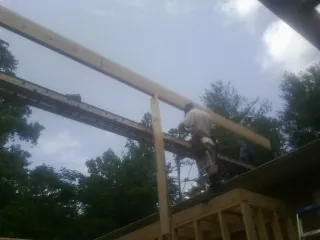 Carpenter setting a ridge beam over a new addition frame — Ice Dam Removal by Roofing Brothers in Turtle Creek