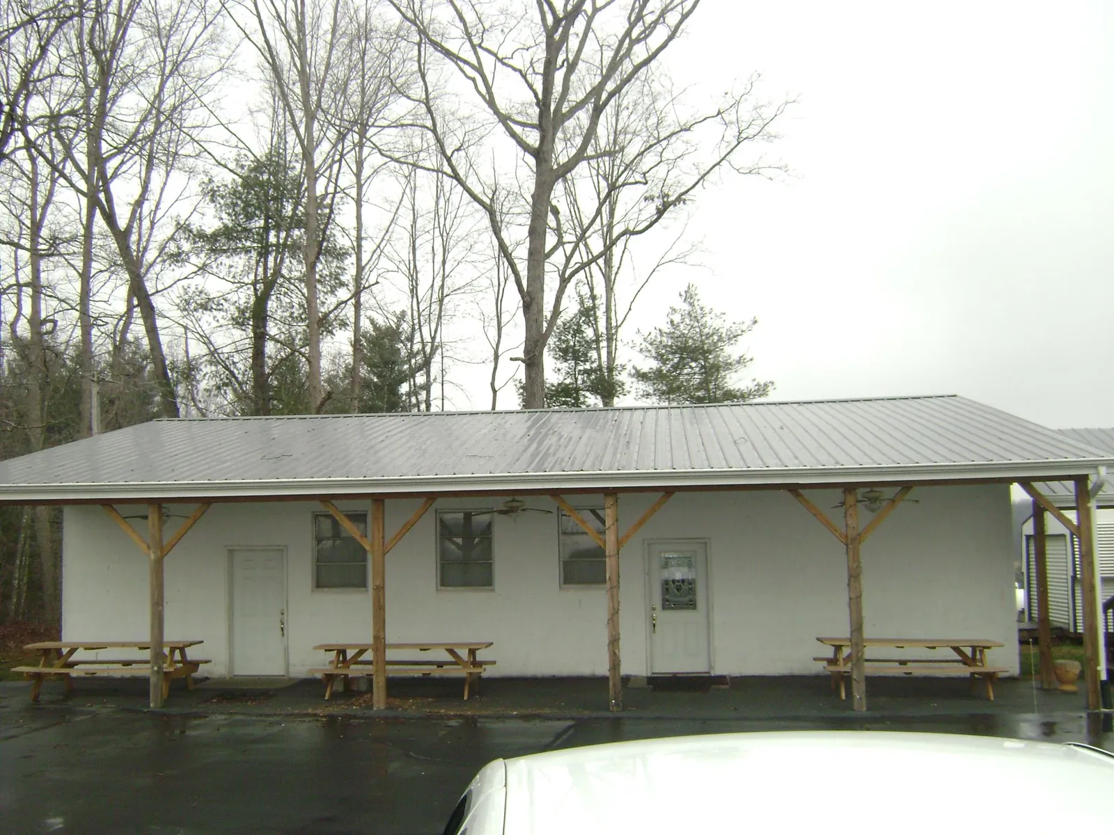 Gray metal roof over a block building with a timber post porch in Turtle Creek