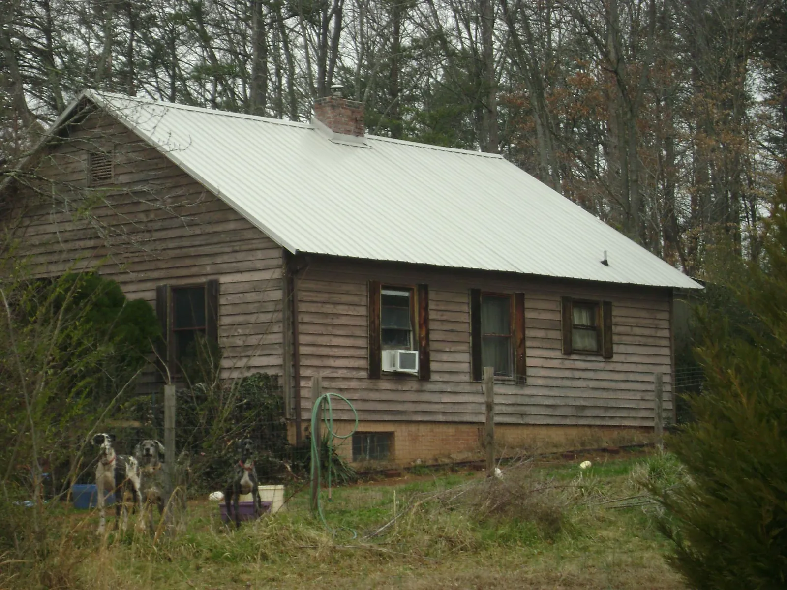 White metal roof on an old wood sided farmhouse, from a Metal Roof Installation job in Turtle Creek